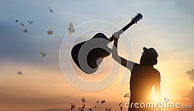 Musician raising guitar over head free birds of silhouette Stock Photo