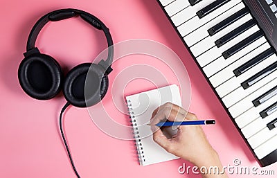 Musician is writing on notebook with studio pink Stock Photo