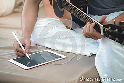 Musicians play guitar and compose songs using the tablet. Stock Photo