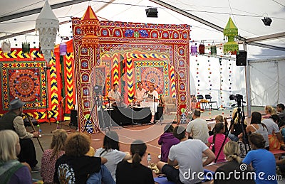 Musicians playing traditional Indian musical instruments on stage, people sitting on a floor and listening to Editorial Stock Photo