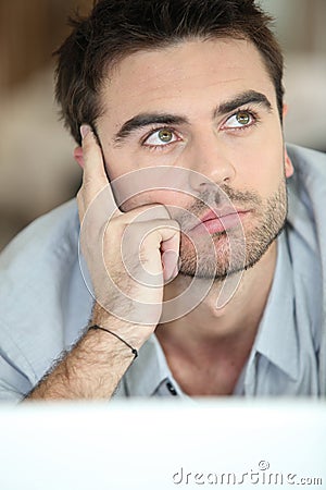 Musing young man looking upwards Stock Photo