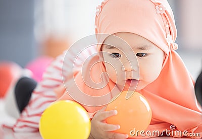 Muslim Baby plays with colorful toys in the living room Stock Photo