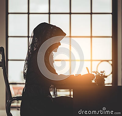 Muslim business people silhouette of islam woman working on office table windows morning flare Stock Photo