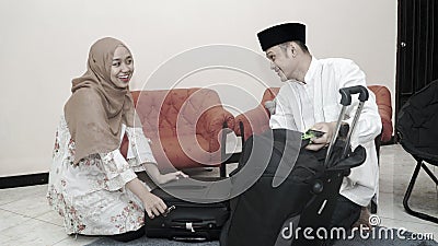 Muslim couple put stuff in suitcase lugage ready for traveling Stock Photo