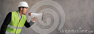 Muslim foreman shouting over grey background. Handsome happy construction worker shouting loud by megaphone with Stock Photo