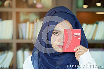 Muslim girl showing a swiss passport Stock Photo