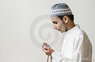 Muslim man praying with tasbih during Ramadan Stock Photo