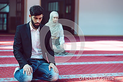 Muslim man and woman praying in mosque Stock Photo
