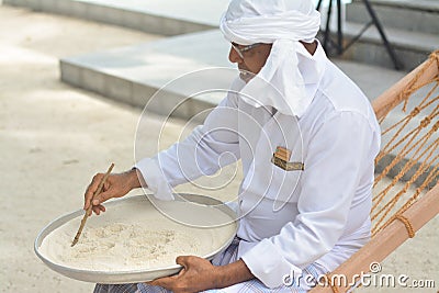 Muslim orthography teacher demonstrate how to write in dhivehi on the sand Editorial Stock Photo