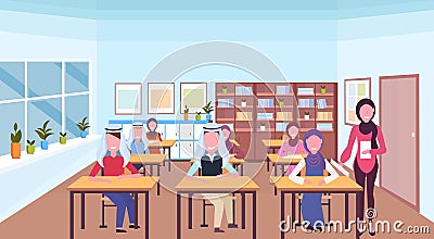 Muslim teacher reading book during lesson arabic pupils in hijab sitting desks education concept modern school classroom Vector Illustration