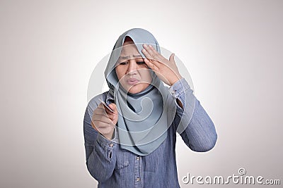 Muslim woman confused and worried when holding credit card Stock Photo