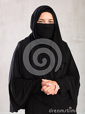 Muslim woman with face covered with burka holds thin fabric of yashmak with her hands Stock Photo
