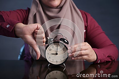 Muslim Woman Holding Clock Pointing at Nine O& x27;Clock, Lateness Concept Stock Photo