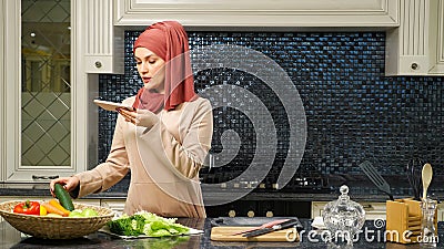 Muslim woman hosts culinary blog telling subscribers recipe Stock Photo