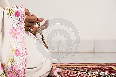 Muslim woman praying close up image of hands as she holds prayer beads,tasbih Stock Photo