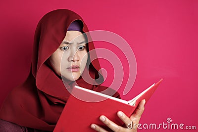 Muslim Woman Shocked when Reading a Book Stock Photo