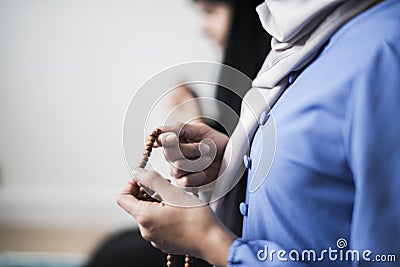 Muslim women using misbaha to keep track of counting in tasbih Stock Photo