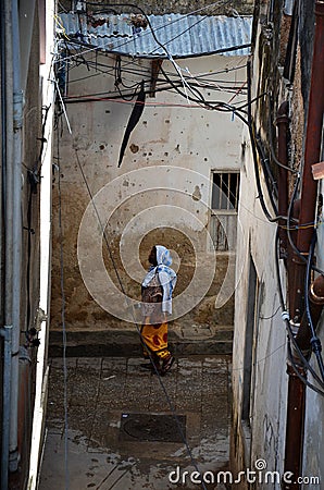 Muslim woman walking through narrow streets Editorial Stock Photo