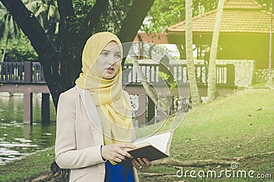 Muslimah woman standing and holding notebooks Stock Photo