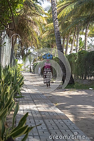 View of pedestrian path, with woman selling street walking and also a man, in Mussulo island Editorial Stock Photo