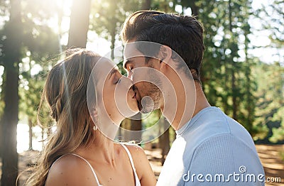 This must be what love feels like. a couple sharing a kiss while spending time together outdoors. Stock Photo