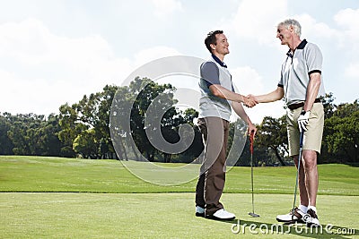 We must play together again soon. Two men shaking hands after a satisfying round of golf. Stock Photo