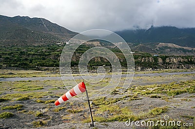 Striped windsock at a local small airfield amid the Himalayan mountains in Jomsom, Nepal Stock Photo