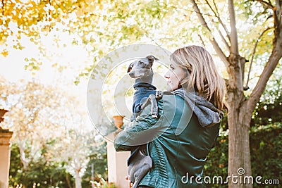 Muzzle of a dog and a woman`s face. Close-up of young and beautiful woman and Italian greyhound - two profiles. Little breed dog Stock Photo