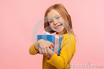 My best present! Delighted charming little girl embracing gift box and smiling joyfully to camera Stock Photo