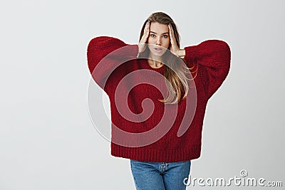 My head is spinning round. Portrait of expressive sensual woman with attractive appearance standing over gray background Stock Photo