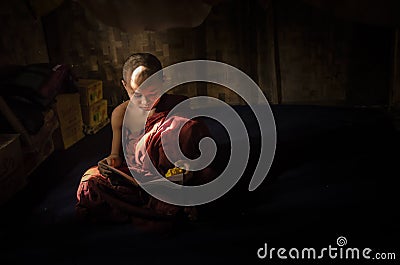 Myanmar - December 5, 2016:Little Novice Monk are reading the book in the cubicle of temple with window light, Mandalay Editorial Stock Photo