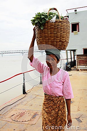 Myanmar woman carrying a basket on her head Editorial Stock Photo