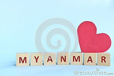 Myanmar word on wooden blocks with red heart shape cutout in blue background. Support, sympathy pray, and send love to Myanmar Stock Photo