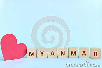 Myanmar word on wooden blocks with red heart shape cutout in blue background. Support, sympathy pray, and send love to Myanmar Stock Photo