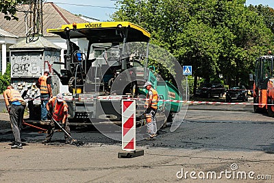 MYKOLAIV, UKRAINE - AUGUST 04, 2021: Workers with road repair machinery laying asphalt Editorial Stock Photo