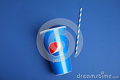 MYKOLAIV, UKRAINE - JUNE 9, 2021: Pepsi cup and straw on blue background, flat lay Editorial Stock Photo