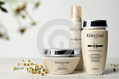 MYKOLAIV, UKRAINE - SEPTEMBER 07, 2021: Set of Kerastase hair care cosmetic products and chamomile flowers on white wooden table Editorial Stock Photo