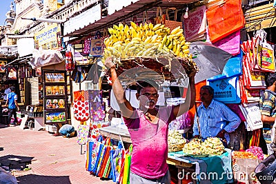 Mysore, India - 12.01.2023 : Devaraja Market, Mysore old traditional street market, man carrying bananas in a basket on Editorial Stock Photo