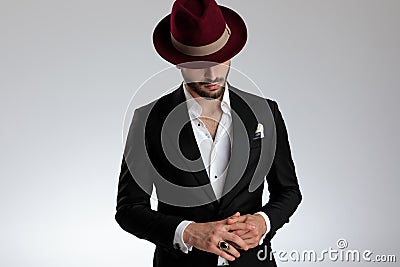 Mysterious businessman holding hands and looking down with hidden eyes Stock Photo