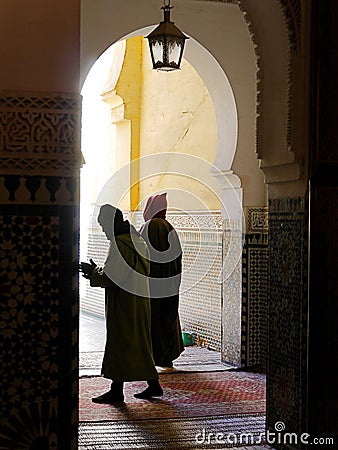 Mysterious cloaked figures in palace archway, Meknes, Morocco Editorial Stock Photo