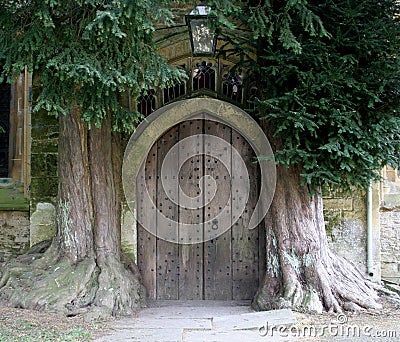 A mysterious door set beside 2 trees on the building of a church in Stow on the Wold in Gloucestershire in the UK Editorial Stock Photo