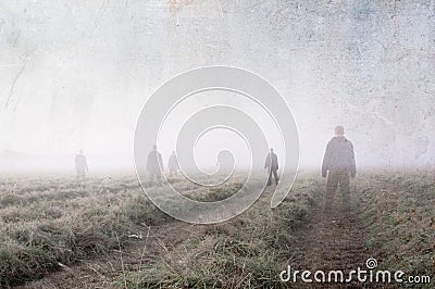 Mysterious ghostly figures, standing and looking out in a cut meadow on a beautiful early misty summer morning. With a grunge, vi Stock Photo