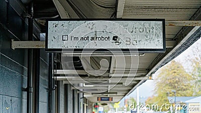 A mysterious I'm not a robot sign hanging over a pavement beside a closed down restaurant Editorial Stock Photo