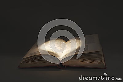Mysterious light draws a heart in the pages of a book of love Stock Photo