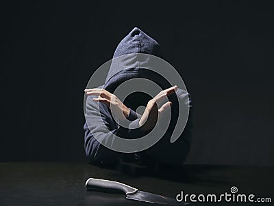 Mysterious man hooded and knife in interrogation room. committed Stock Photo