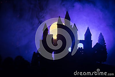 Mysterious medieval castle in a misty full moon. Abandoned gothic style old castle at night Stock Photo