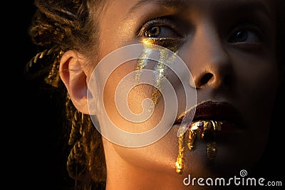 Mysterious mystical heroine with golden drops on her face, Stock Photo