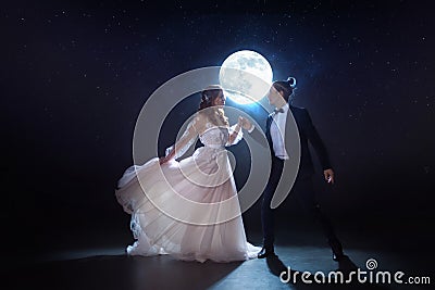 Mysterious and romantic meeting, the bride and groom under the moon. Hugs together. Mixed media Stock Photo