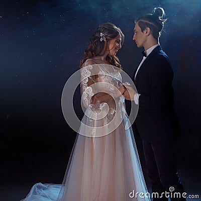 Mysterious and romantic meeting, the bride and groom under the moon. Hugs together. Mixed media Stock Photo