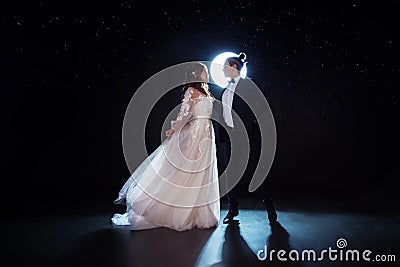 Mysterious and romantic meeting, the bride and groom under the starry sky. Hugs together. Man and woman, wedding dress. Stock Photo